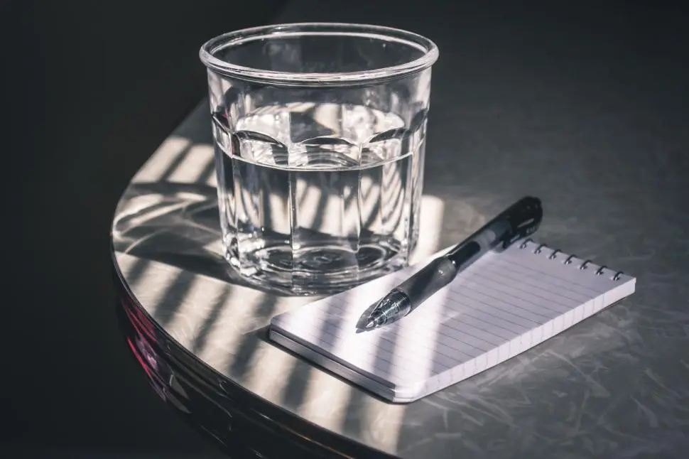 Consultation desk with notebook, pen and a glass carafe of water